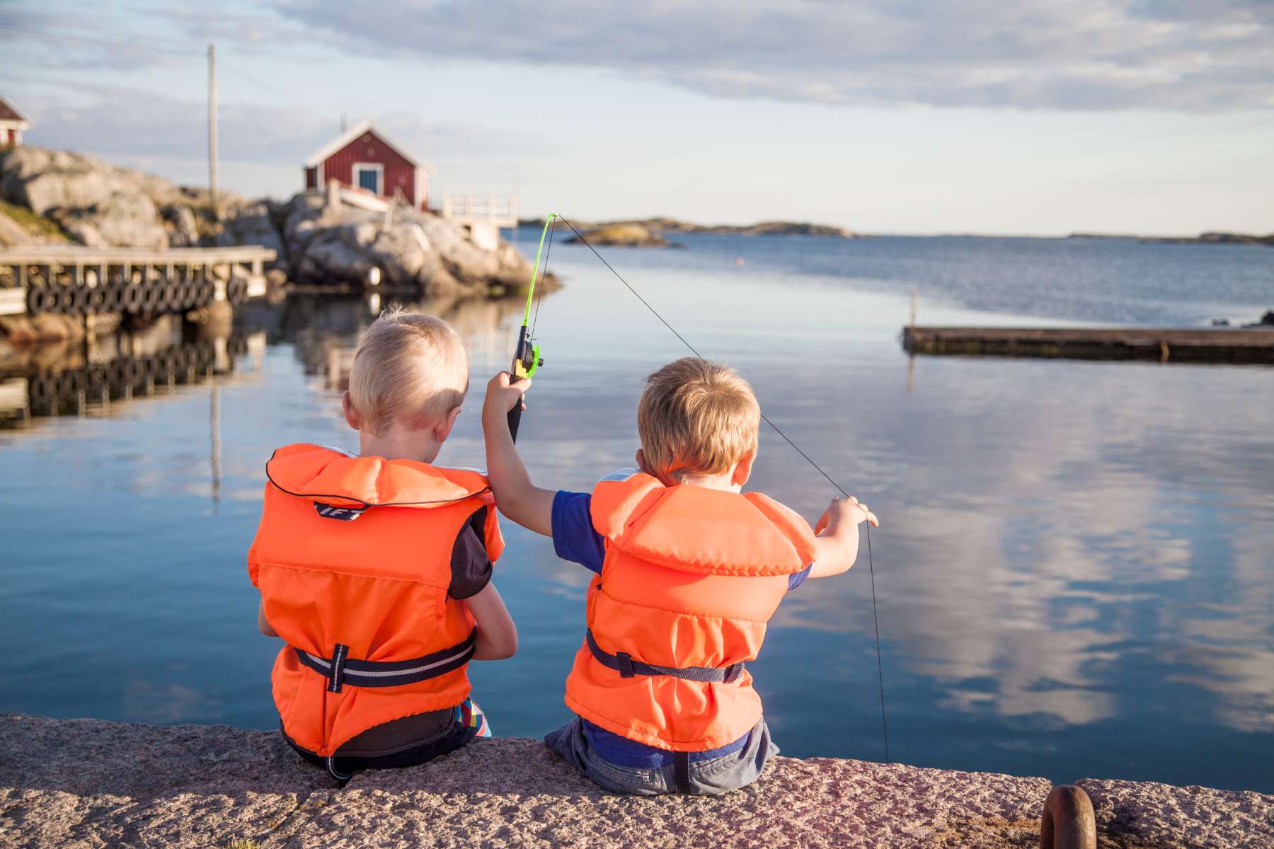 Barn som fisker utenfor hytta
